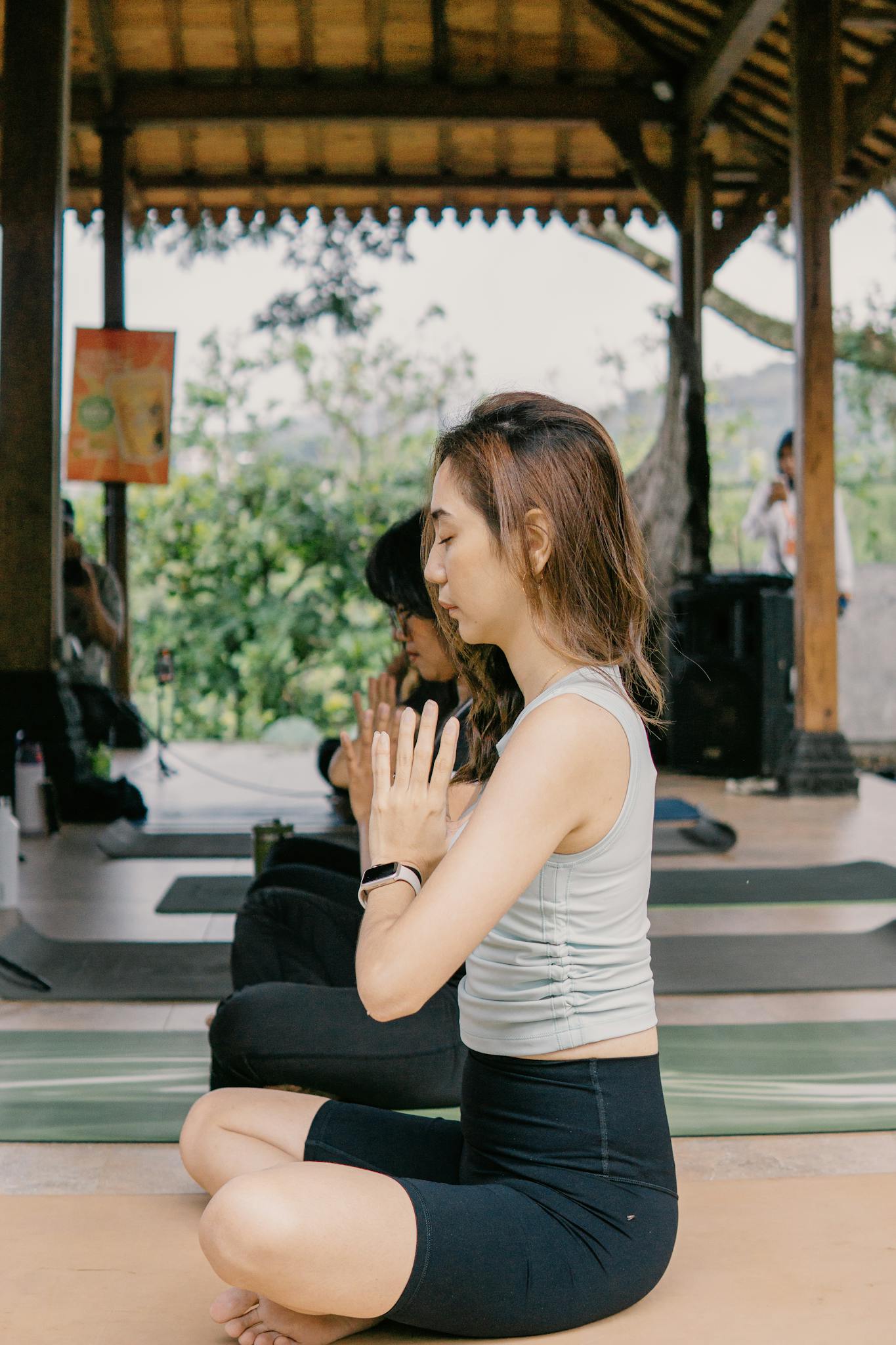 Group of women practicing yoga in a peaceful outdoor setting in Jawa Barat, Indonesia.